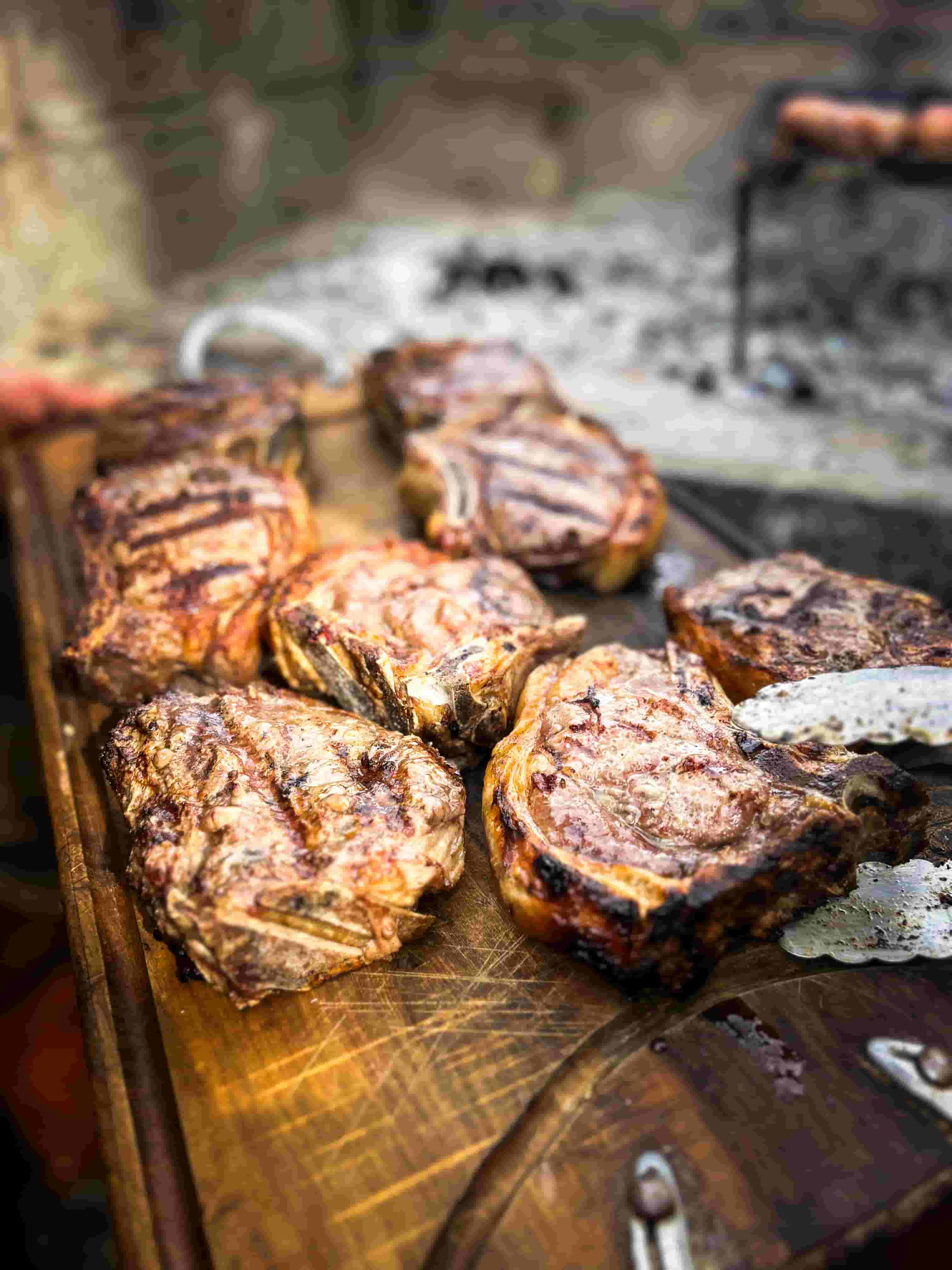 Bife vacuno cortado mostrando el centro rosado del punto jugoso sobre una tabla de madera