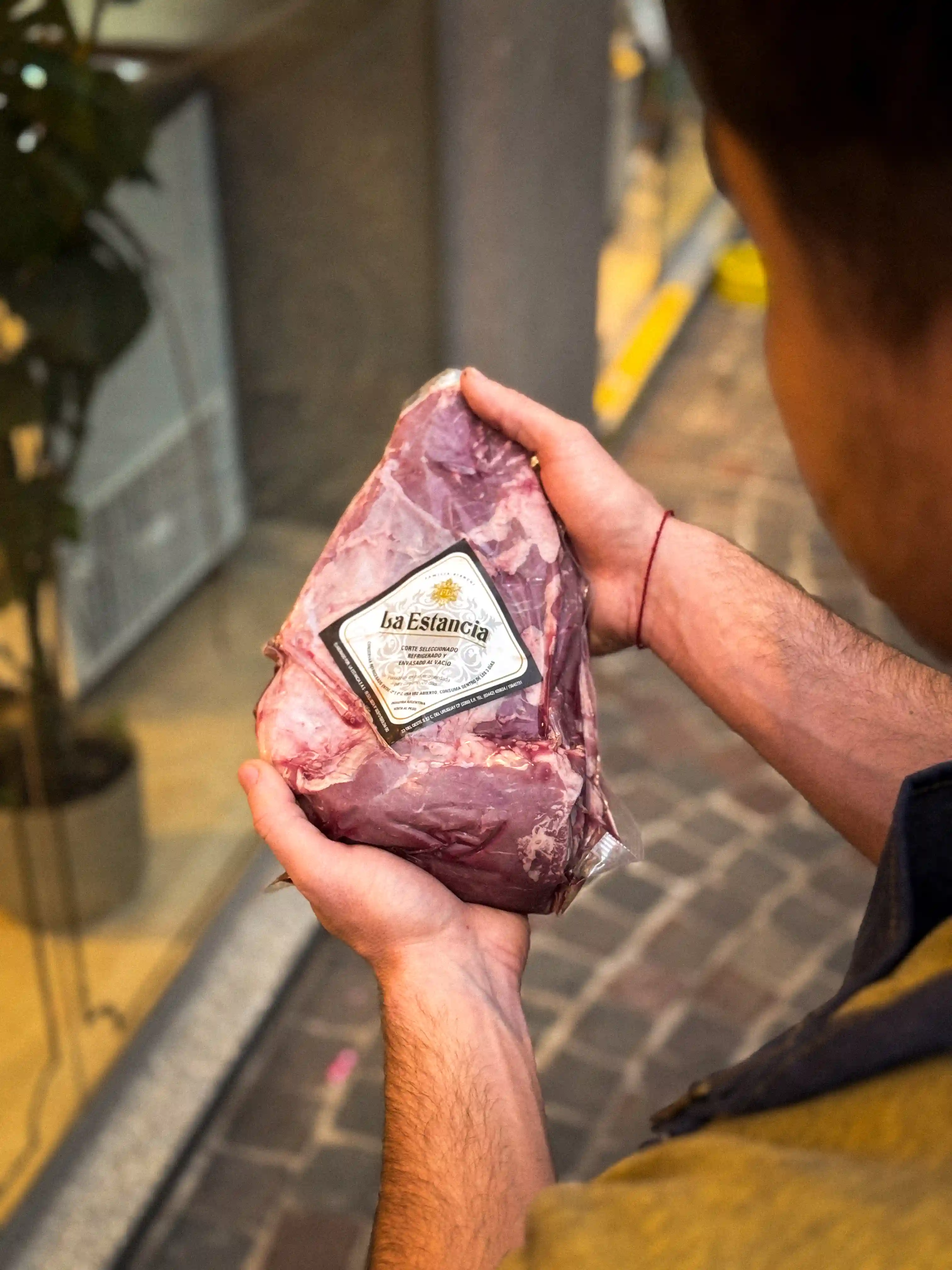 Picaña con su capa de grasa marcada en rombos, dorada y lista para cortar sobre tabla de madera